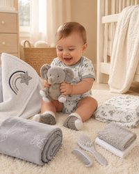 Grey - 9TR40-G - Baby playing with the animal soft toy, surrounded by muslins, the fleece blanket and cotton garments from the grey hamper
