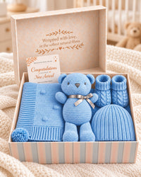Blue knitted cotton baby gift set in presentation box with blue blanket, teddy bear, booties, beanie and greeting card
